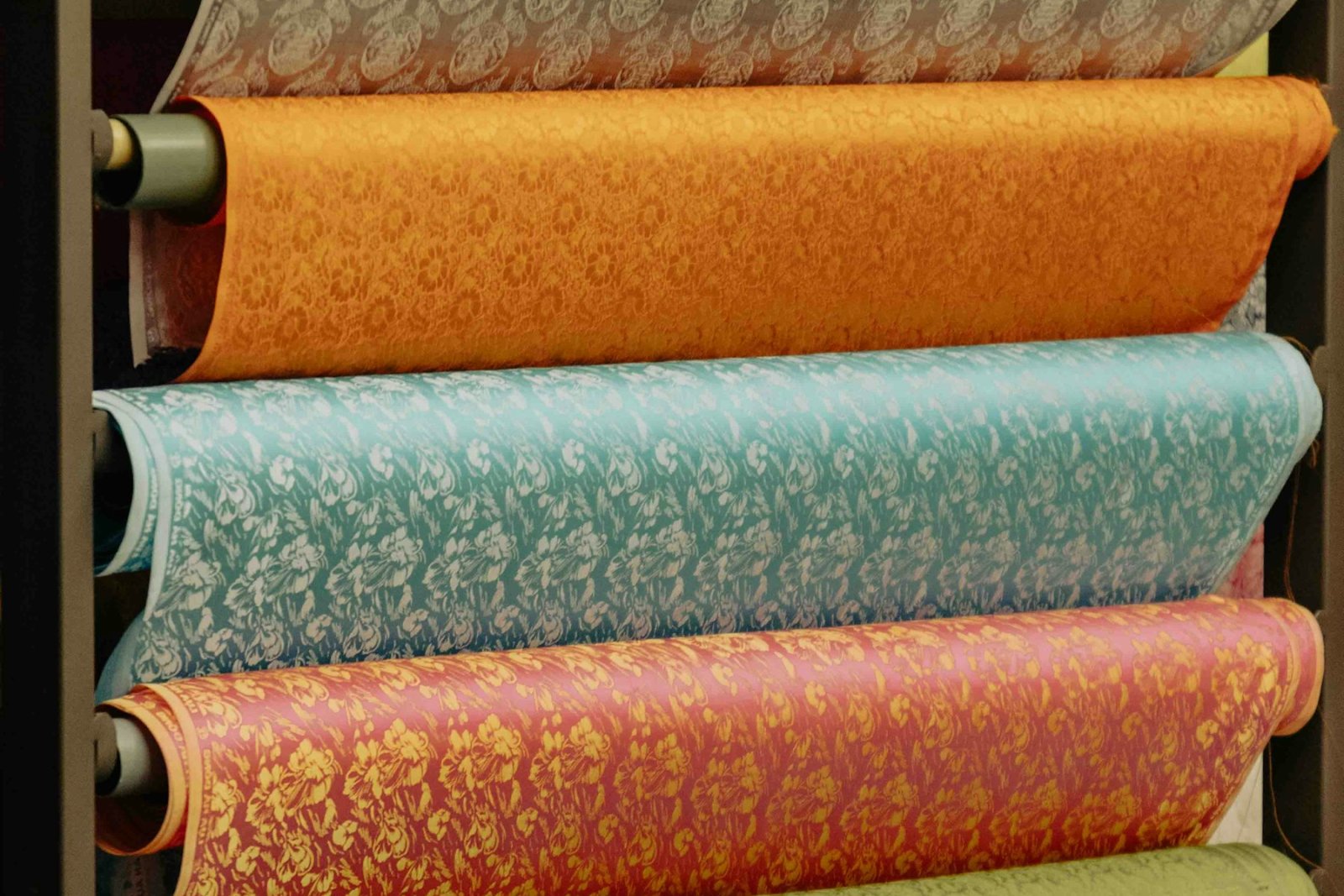 Rolls of patterned upholstery fabric stacked on shelves
