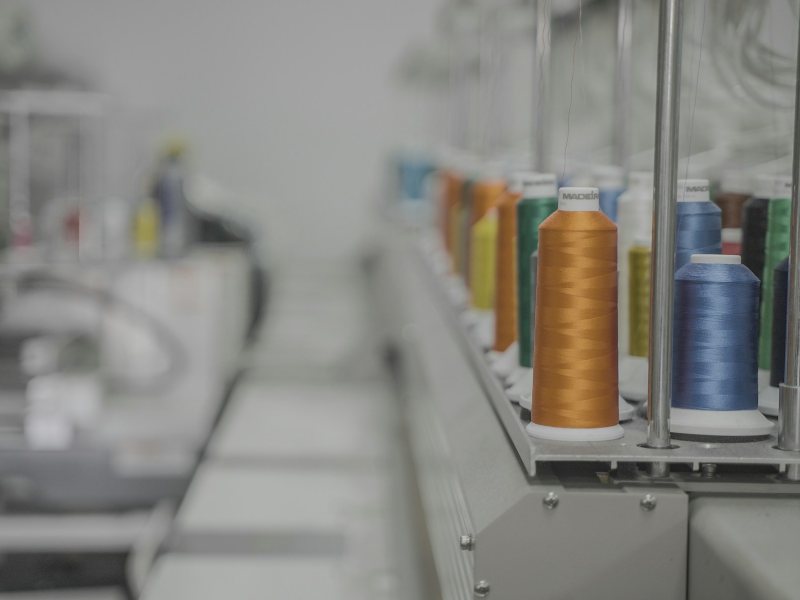 Dyed thread cones lined up on an industrial machine