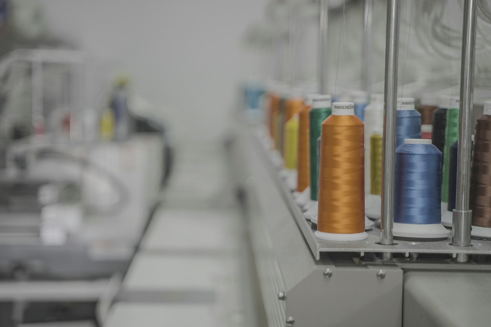 Dyed thread cones lined up on an industrial machine